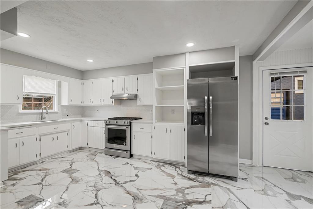309 Beech Street Vandergrift, PA 15690 - Photo 8 of 47 a kitchen with granite countertop a refrigerator and a stove top oven