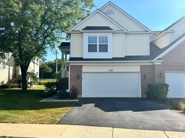 a front view of a house with a yard and garage