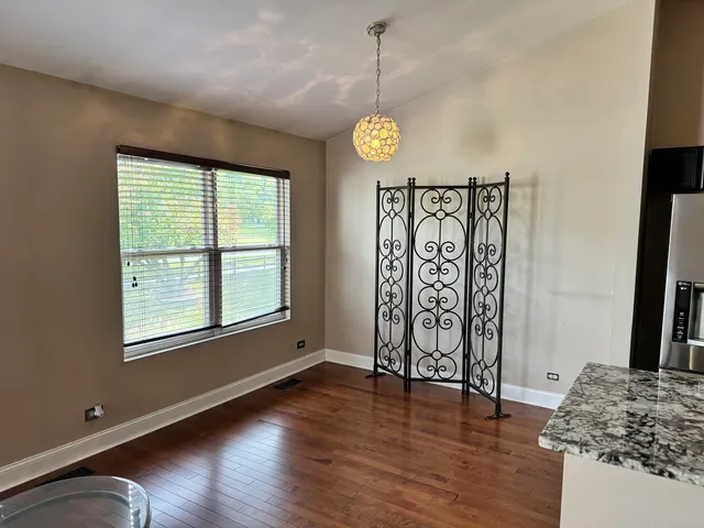 a view of an empty room with window wooden floor and front door
