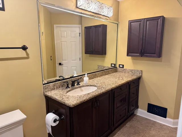 a bathroom with a granite countertop sink and a mirror