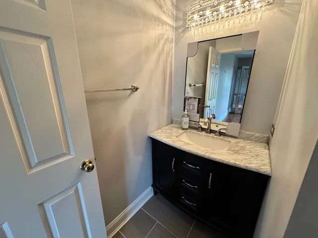 a bathroom with a granite countertop sink vanity and mirror