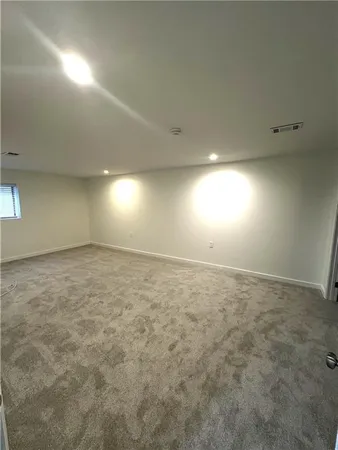 an empty room with yellow lighting and windows