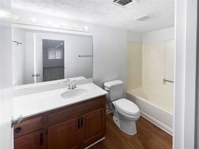 a bathroom with a sink a toilet a mirror and shower