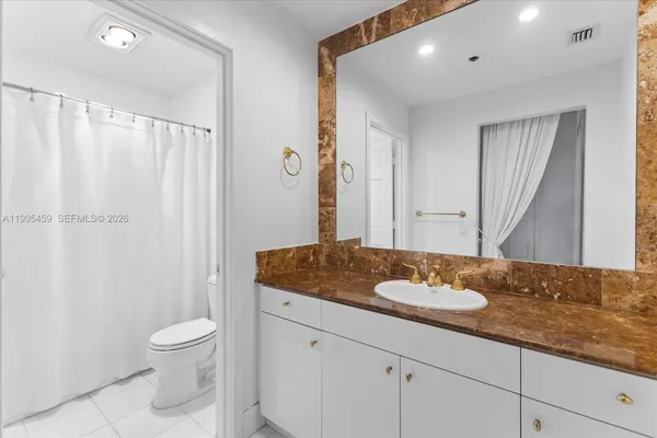 a bathroom with a granite countertop sink toilet and shower