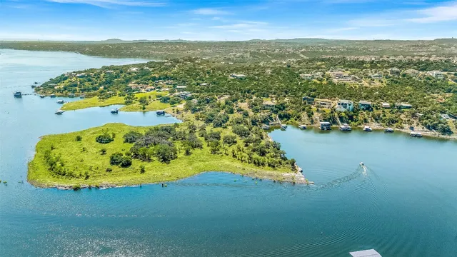 an aerial view of residential houses with outdoor space and ocean view