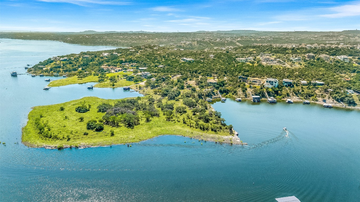 an aerial view of residential houses with outdoor space and ocean view