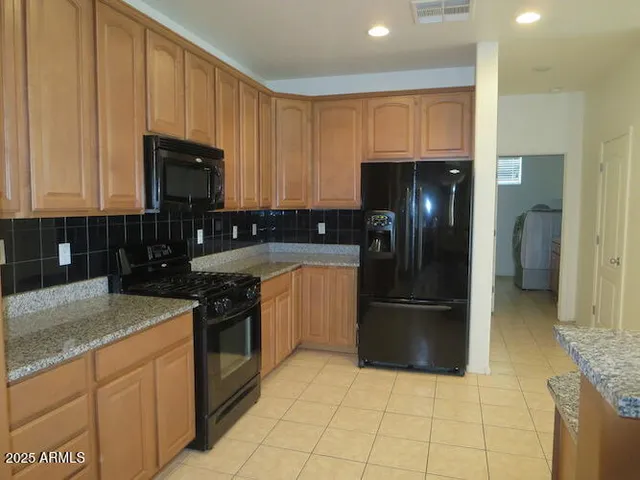 a kitchen with stainless steel appliances granite countertop a refrigerator stove and sink