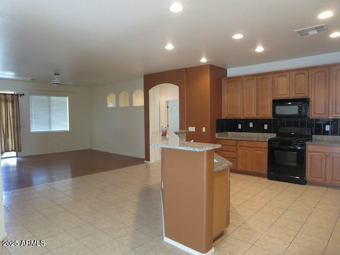 7120 South 68th Avenue Laveen, AZ 85339 - Photo 6 of 17 a kitchen with kitchen island granite countertop a stove top oven a sink a counter space and cabinets