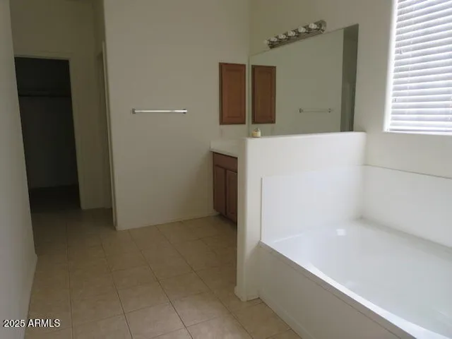 a bathroom with a bathtub sink and mirror