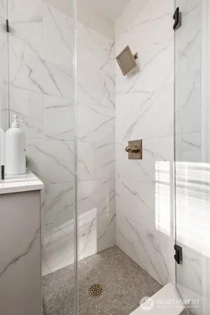 a bedroom with a bed a mirror on the dresser and a window