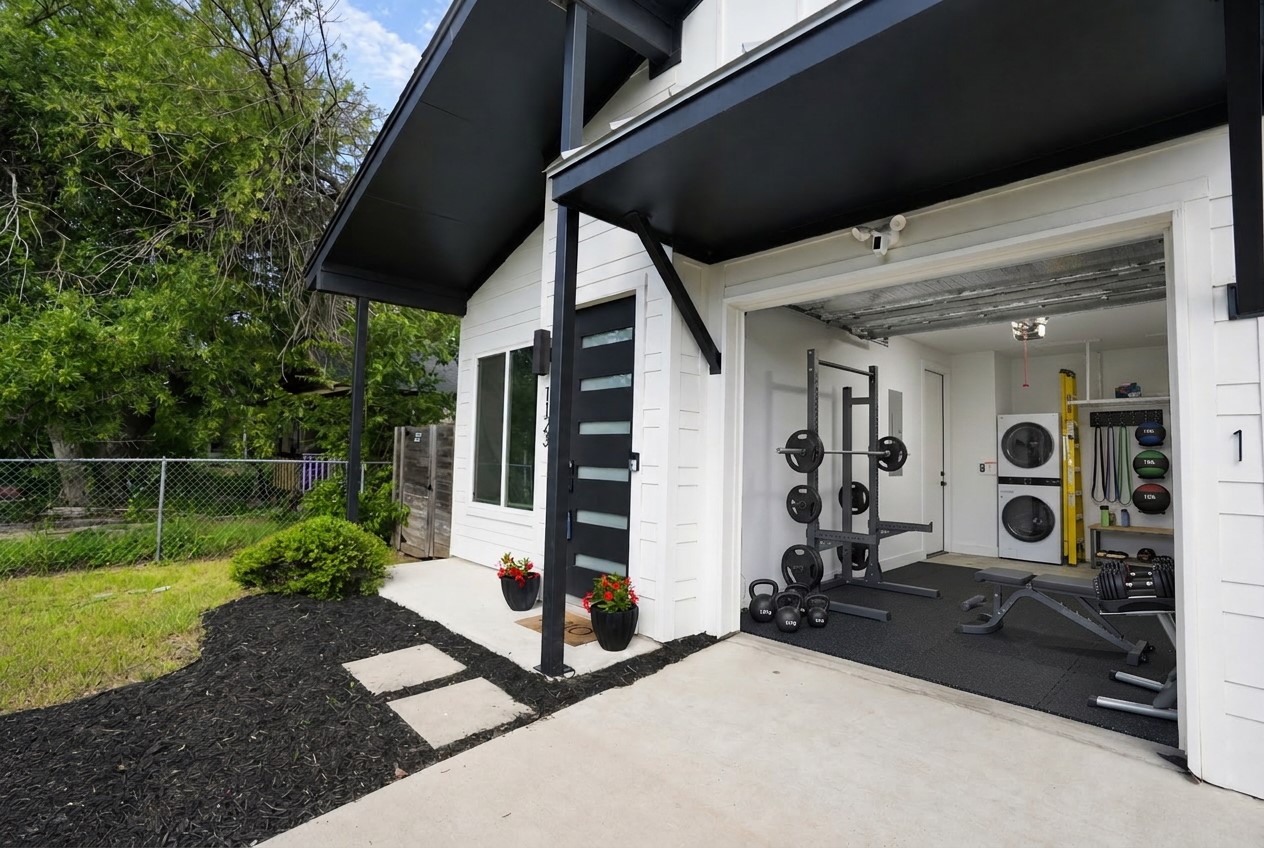 1123 Omega Avenue, Unit 1 Austin, TX 78721 - Photo 4 of 39 A modern exterior facade showcasing a stylish entry and an open-air garage gym.