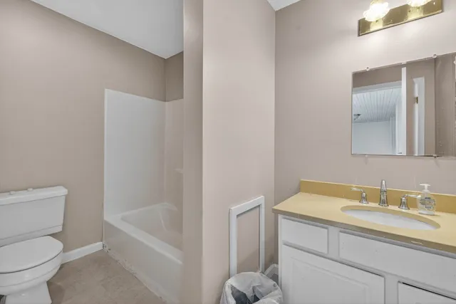 a bathroom with a granite countertop toilet a sink and a bathtub