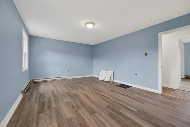 a view of an empty room with wooden floor