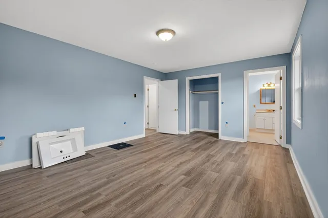 an empty room with closet and wooden floor