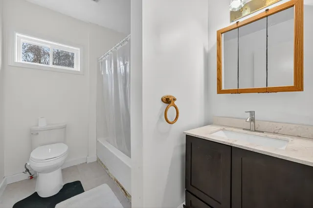 a bathroom with a granite countertop sink toilet and mirror