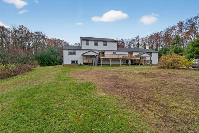 a view of a house with a yard and sitting area