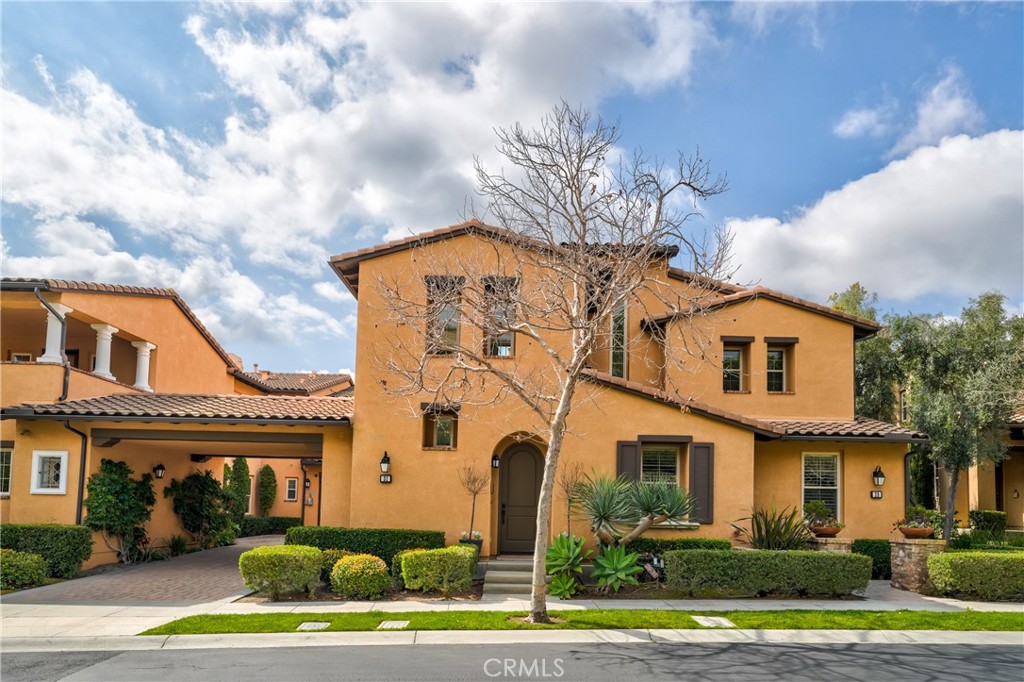 a front view of a house with a garden and plants