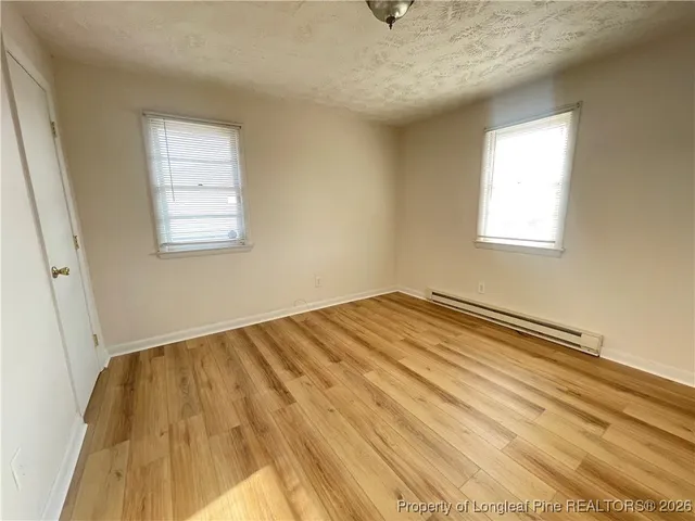 a view of a room with wooden floor and fan