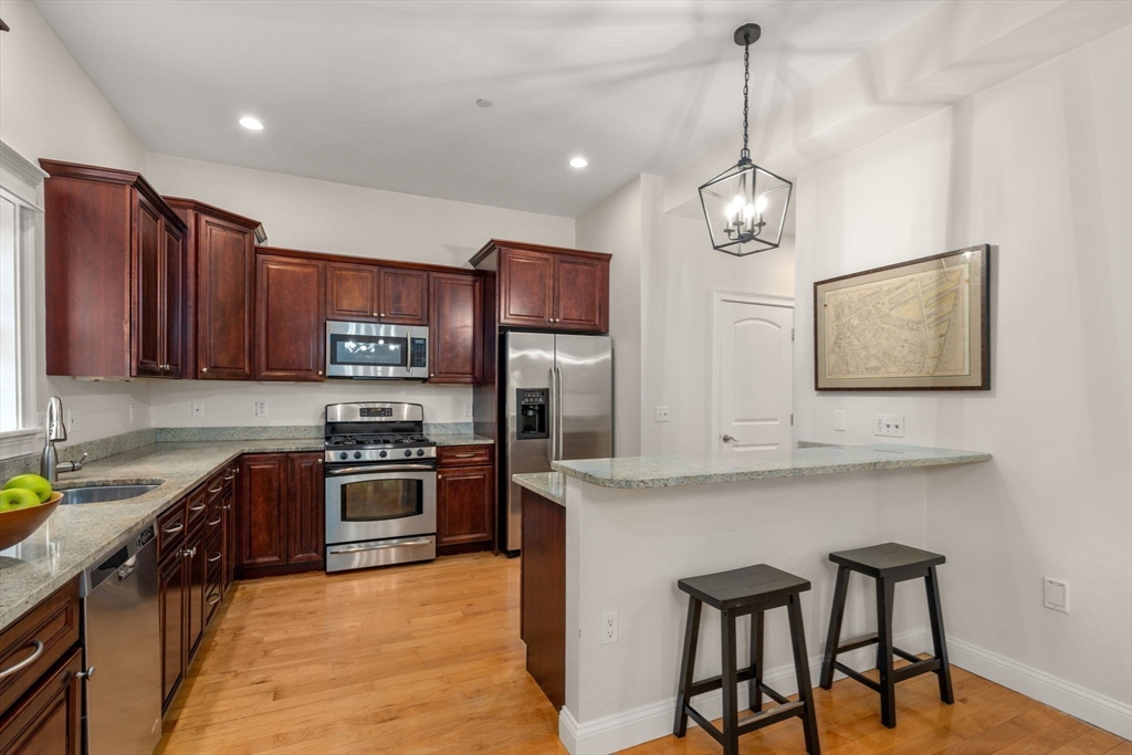809 Boston Post Road, Unit B Weston, MA 02493 - Photo 16 of 39 a kitchen with stainless steel appliances granite countertop a stove top oven a sink dishwasher a dining table and chairs with wooden floor
