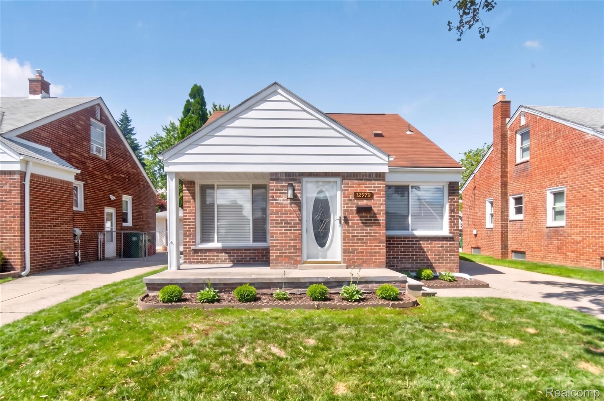 Brick exterior with white siding accents and a red shingle roof