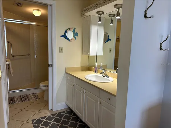 a bathroom with a granite countertop sink toilet and shower