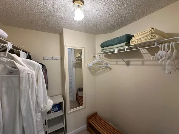 a view of walk in closet with clothes and shoes
