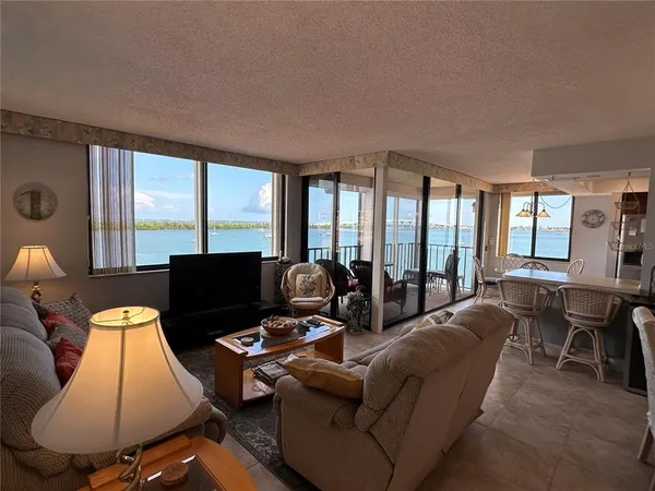 a living room with furniture fireplace and large windows