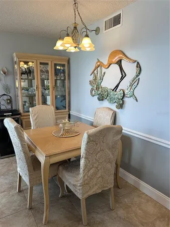 a dining room with furniture a chandelier and window