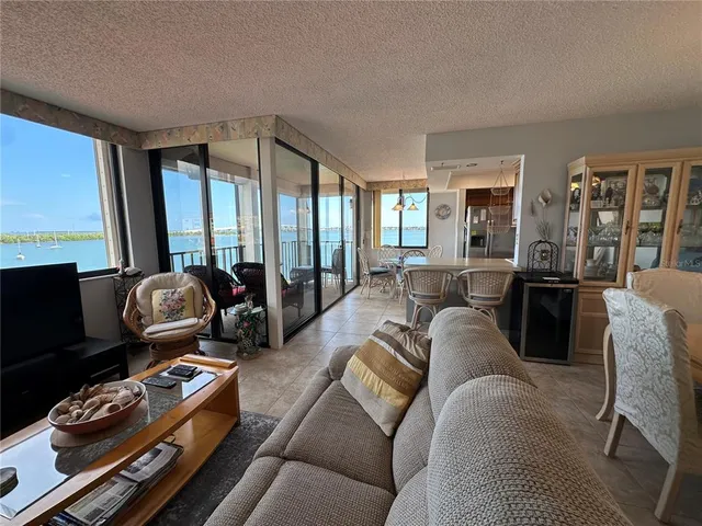 a living room with furniture floor to ceiling window and flat screen tv