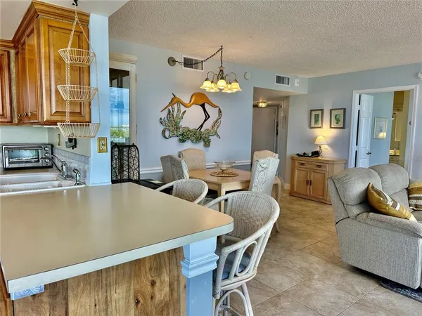 a living room with furniture a chandelier and a dining table