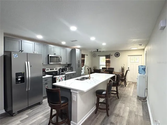 a kitchen with a dining table chairs refrigerator and cabinets
