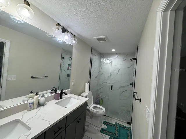 a spacious bathroom with a double vanity sink toilet and a mirror