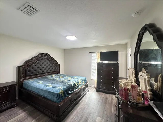 a bedroom with a bed and a mirror on dresser