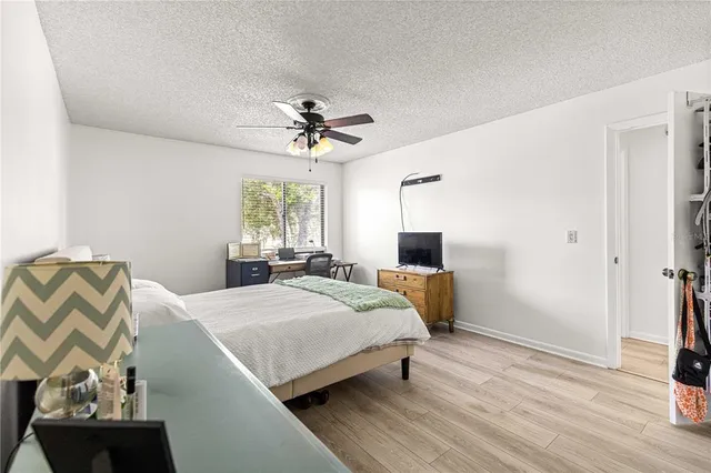 a bedroom with a bed a chandelier and a couch