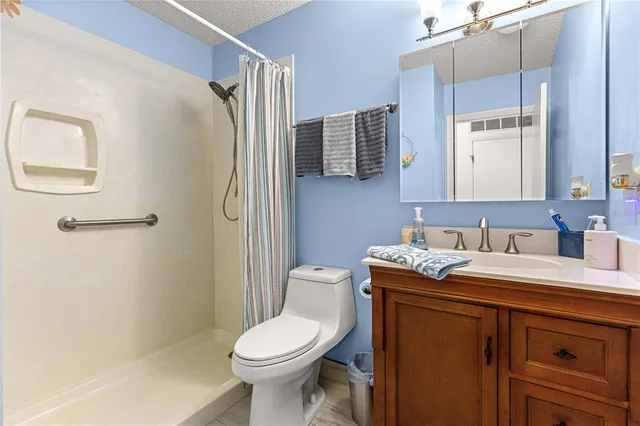 a bathroom with a granite countertop toilet sink and mirror