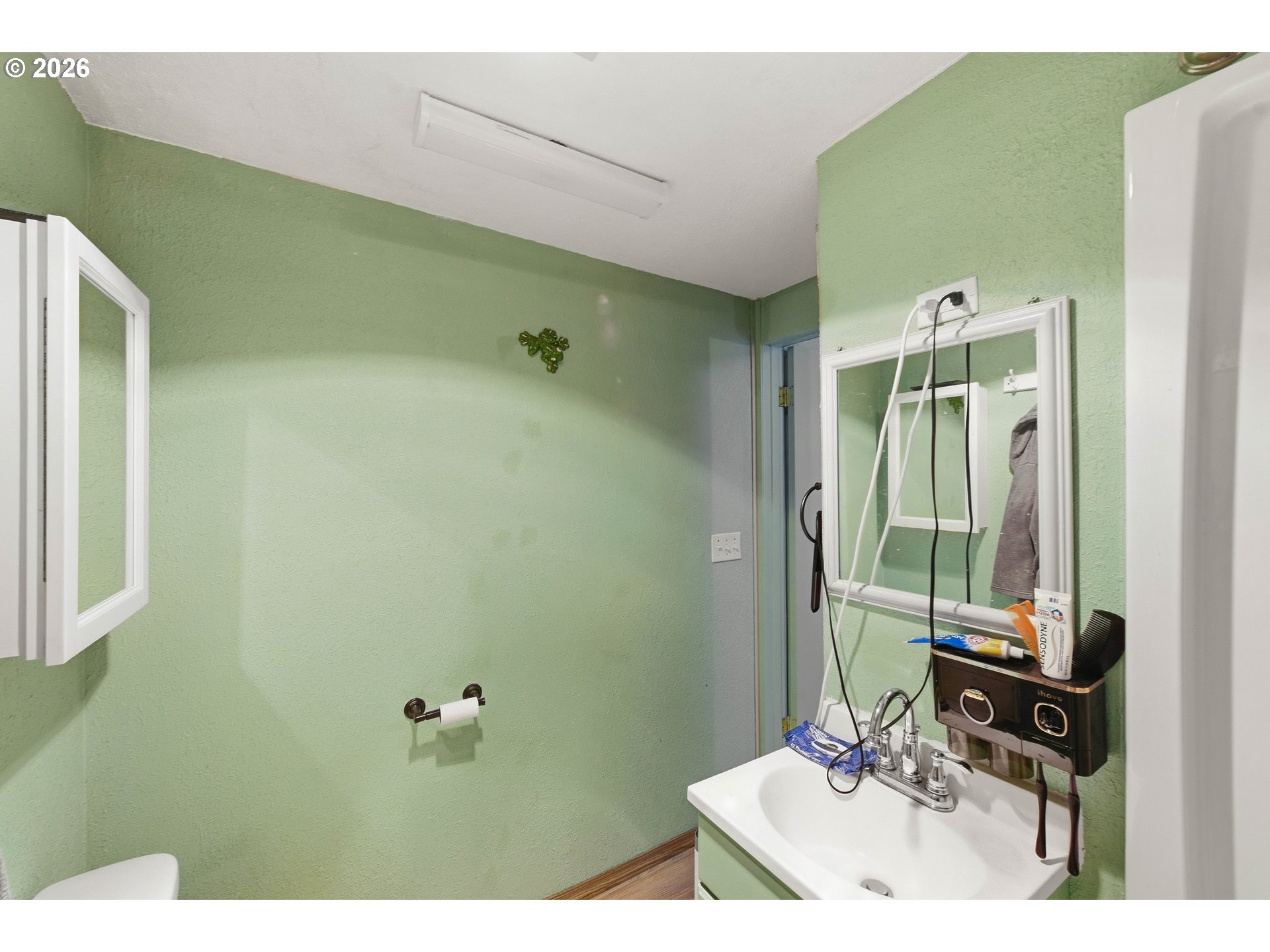 1955 Maple Street North Bend, OR 97459 - Photo 21 of 48 a bathroom with a sink a mirror and a shower