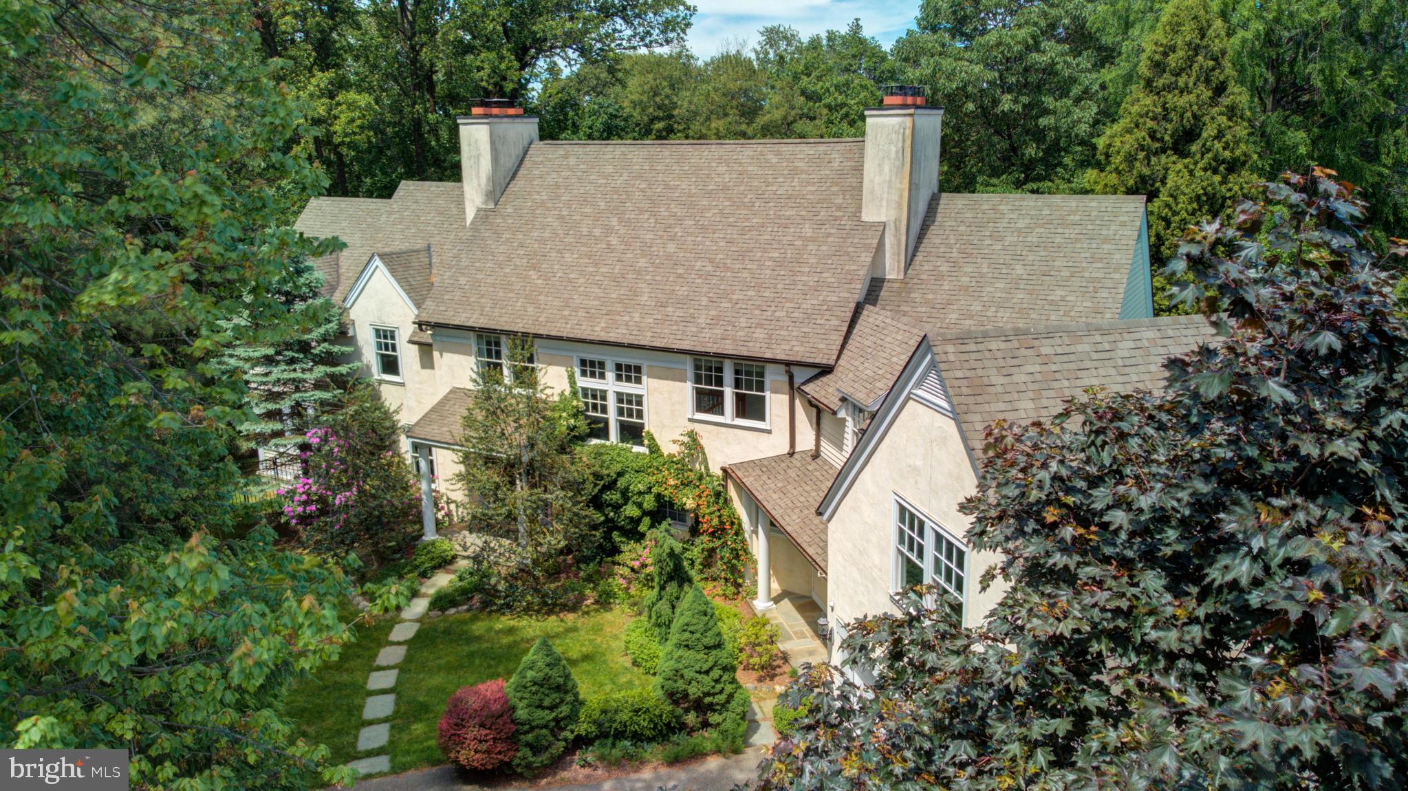 an aerial view of a house with a yard and large trees