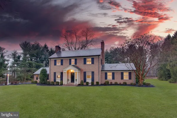 a view of a big house with a big yard and large trees