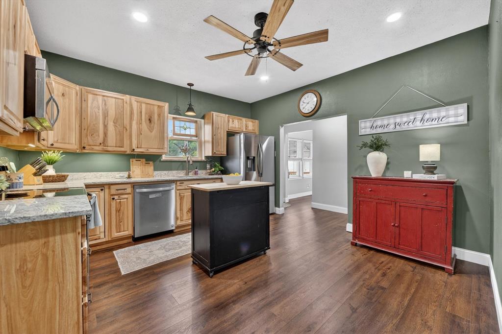 1808 Silver Creek Azle Road Azle, TX 76020 - Photo 11 of 32 a kitchen with kitchen island granite countertop wooden floors stainless steel appliances a sink and cabinets