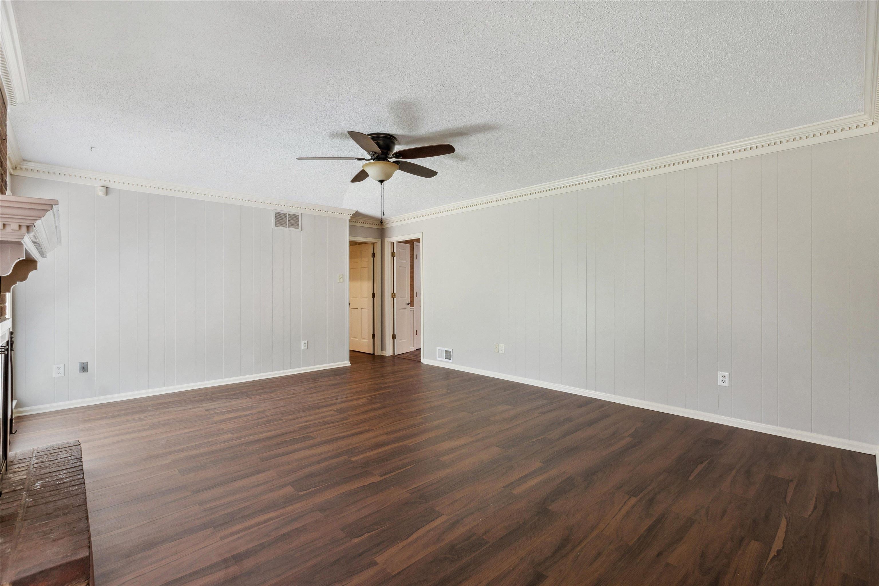 7617 Hollow Fork Road Germantown, TN 38138 - Photo 11 of 28 a view of an empty room with wooden floor and a ceiling fan