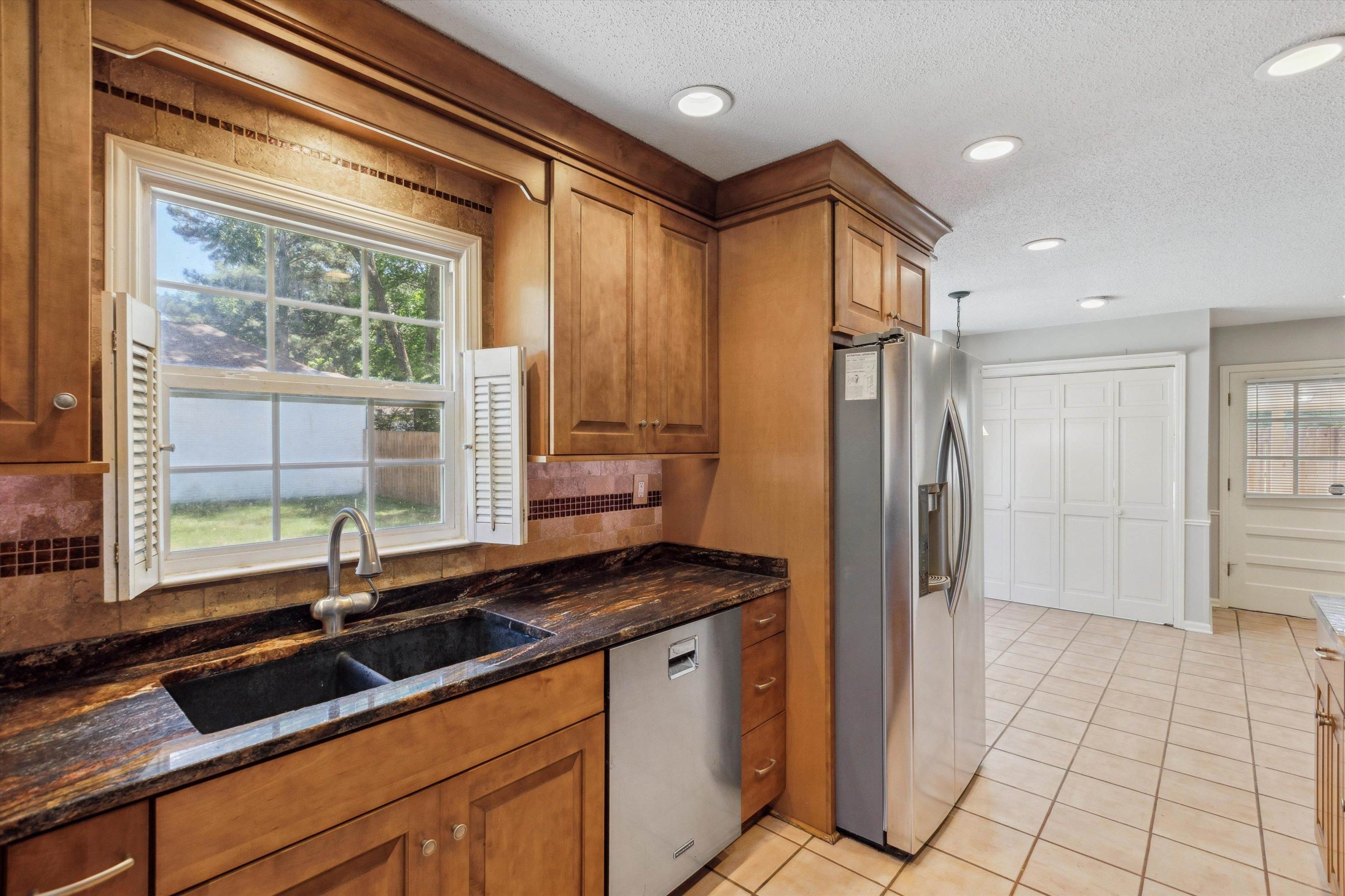 7617 Hollow Fork Road Germantown, TN 38138 - Photo 12 of 28 a kitchen with granite countertop a sink and a refrigerator