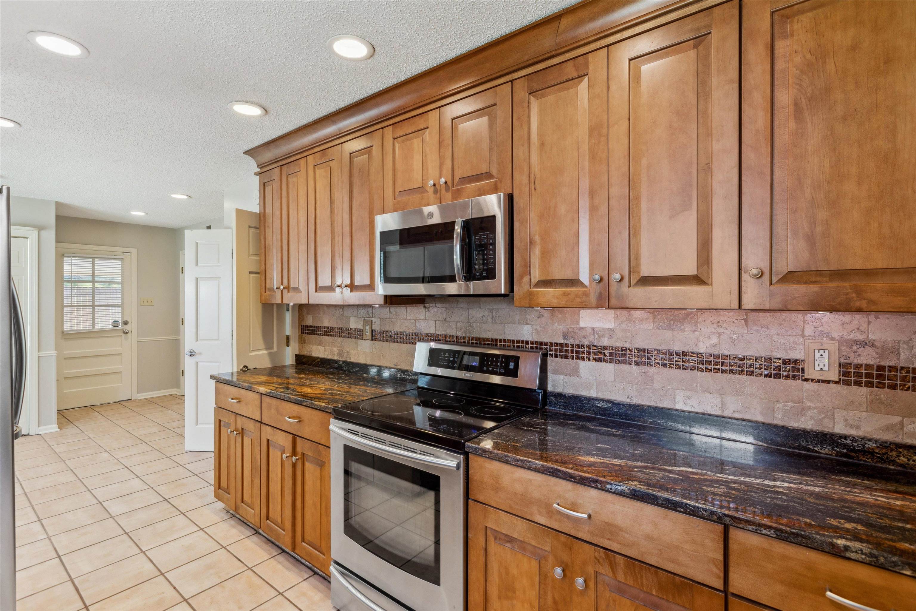 7617 Hollow Fork Road Germantown, TN 38138 - Photo 13 of 28 a kitchen with stainless steel appliances granite countertop a stove a sink and a microwave