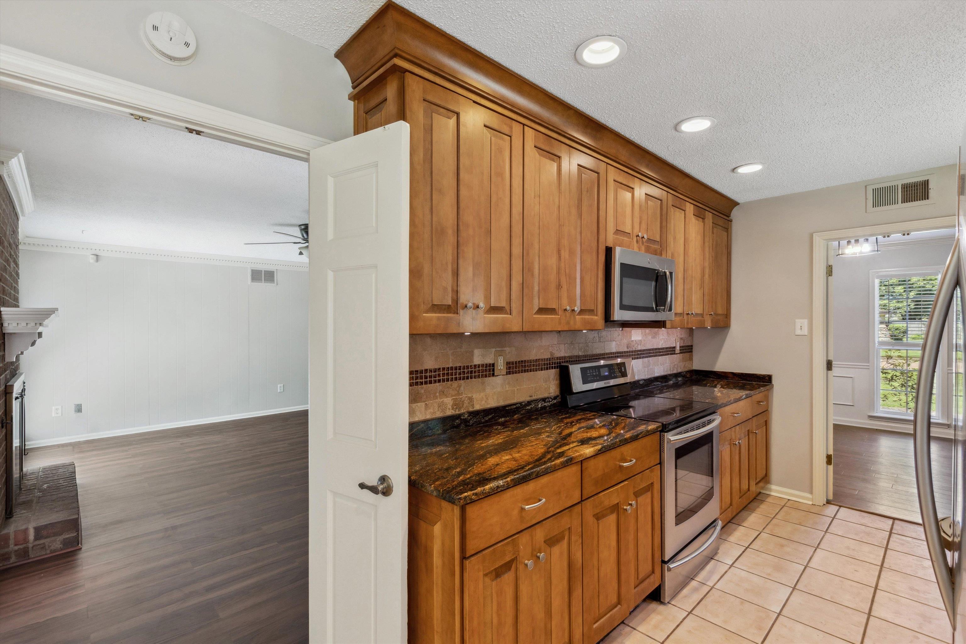 7617 Hollow Fork Road Germantown, TN 38138 - Photo 14 of 28 a kitchen with stainless steel appliances granite countertop a stove a sink and a refrigerator