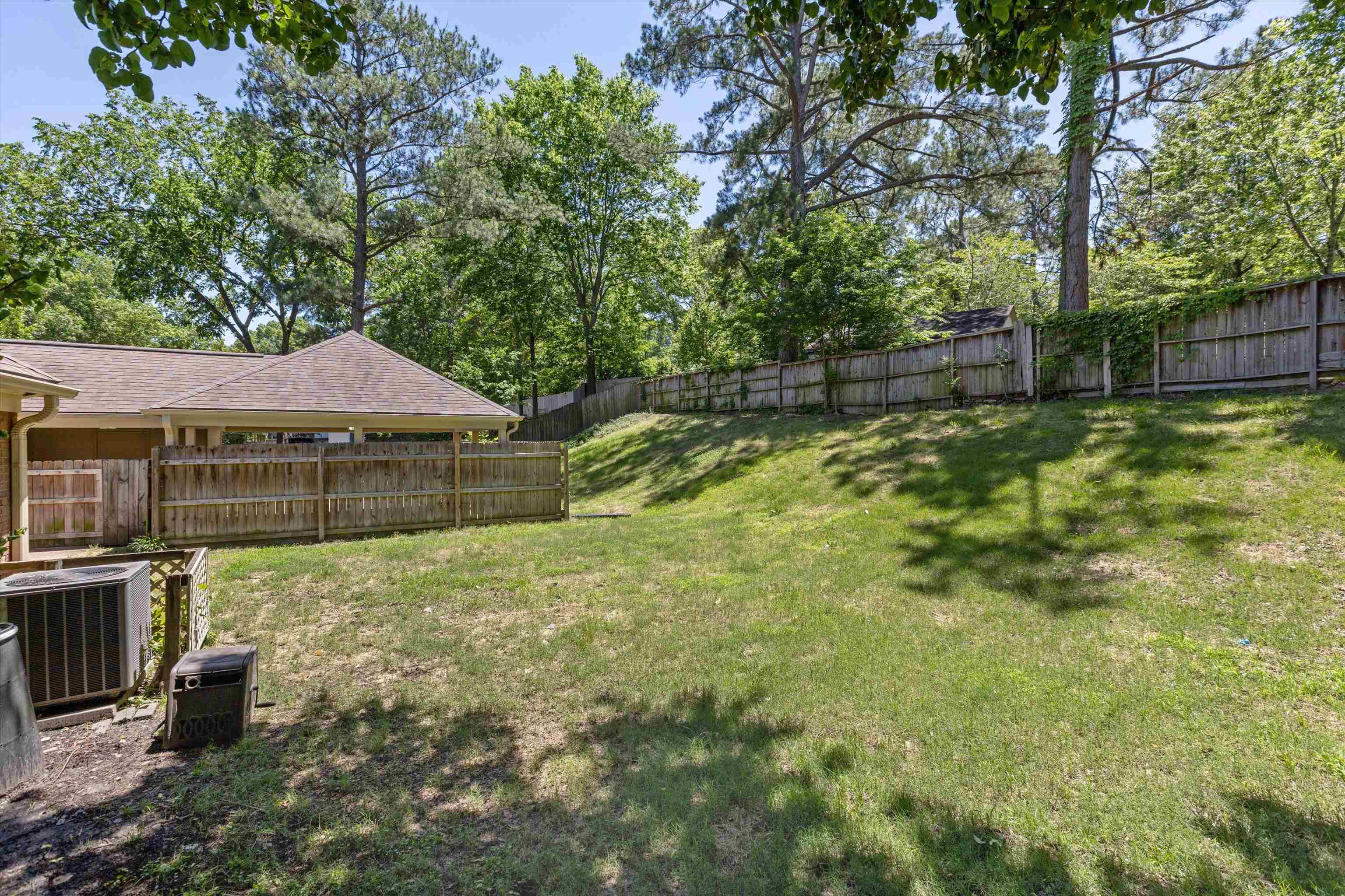 7617 Hollow Fork Road Germantown, TN 38138 - Photo 25 of 28 a backyard of a house with large trees and wooden fence