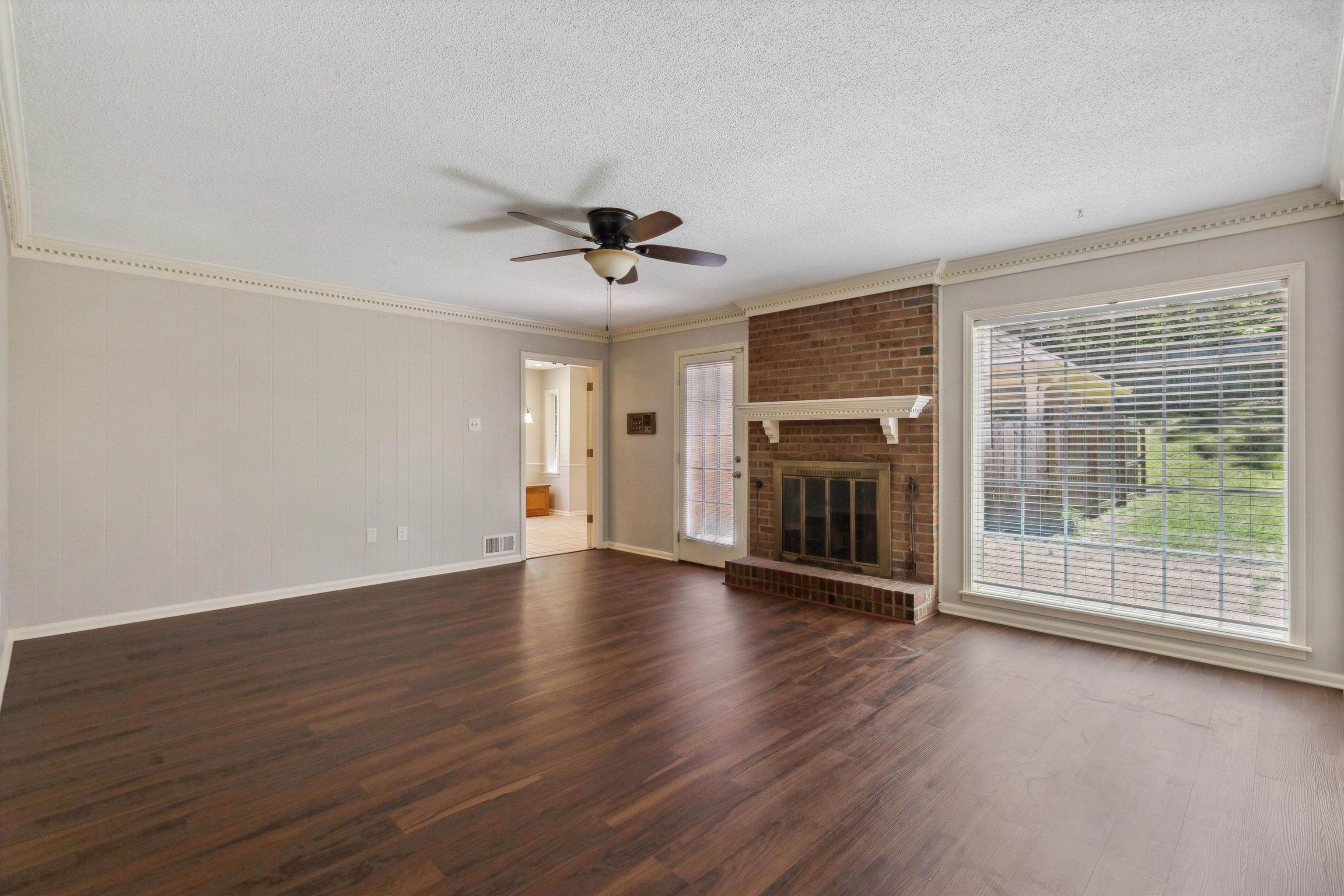 7617 Hollow Fork Road Germantown, TN 38138 - Photo 10 of 28 a view of an empty room with wooden floor and a fireplace
