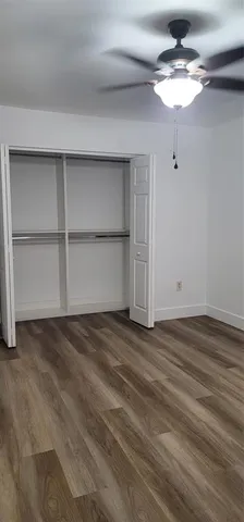 a view of an empty room with a ceiling fan and window