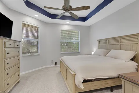 a bedroom with a bed a flat screen tv and a window