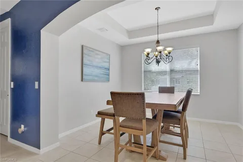 a dining room with furniture a chandelier and window
