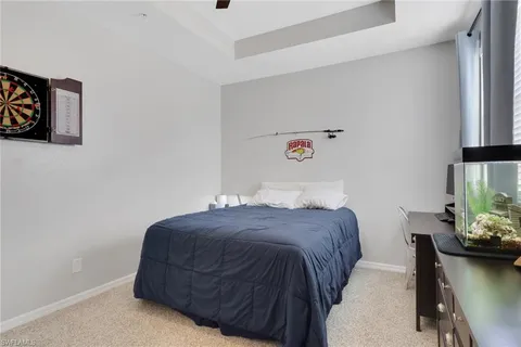 a bedroom with a bed and a potted plant on the dresser