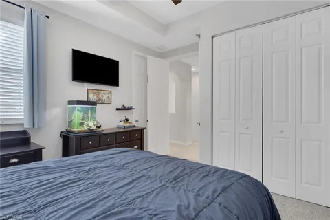 a room with a bed and a flat tv screen on dresser
